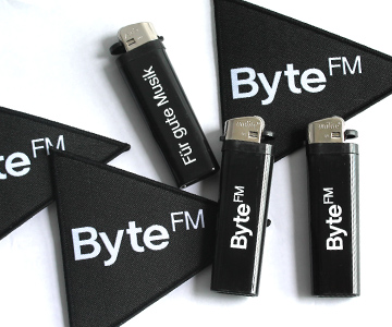 Neu im ByteFM Shop: Feuerzeug und Aufnäher