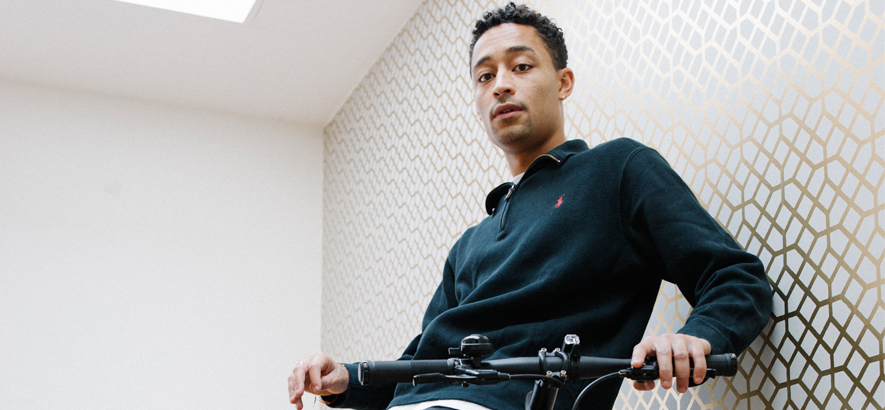 Foto des Rappers Loyle Carner mit seinem Fahrrad. Carners von Madlib produzierter Song „Yesterday“ ist heute unser Track des Tages.