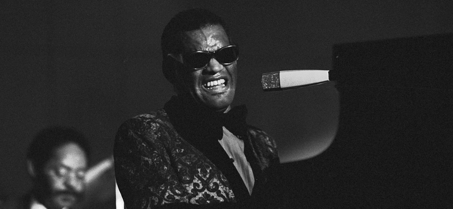 Foto von Ray Charles, der am Klavier sitzt